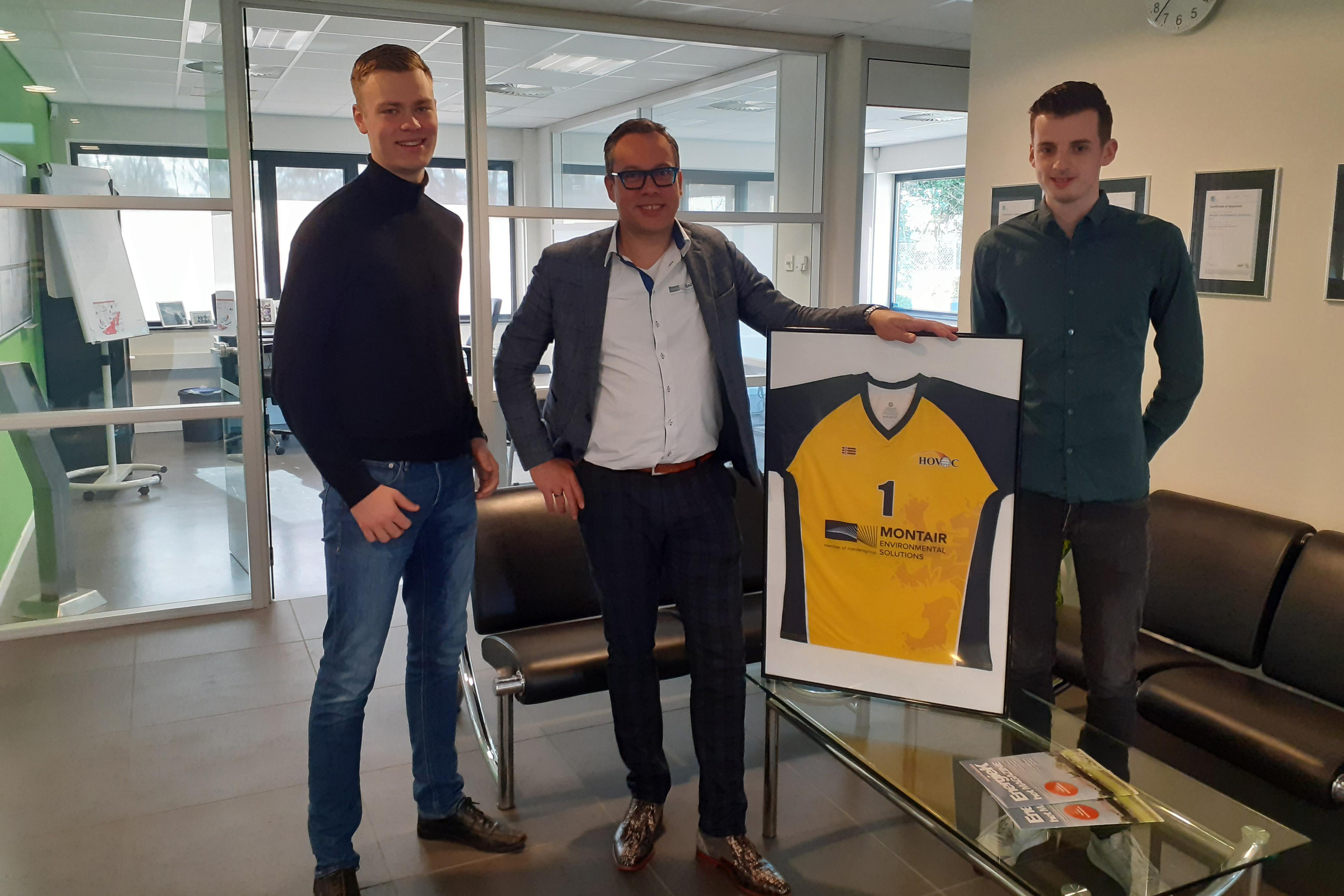 Tom van Asten met twee leden van HOVAC en het volleybalshirt met sponsorlogo
