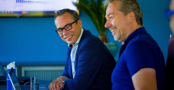 Tom van Asten and Maik Wilms laugh during a meeting