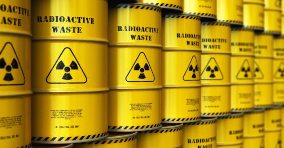 Decorative image of yellow barrels with nuclear waste