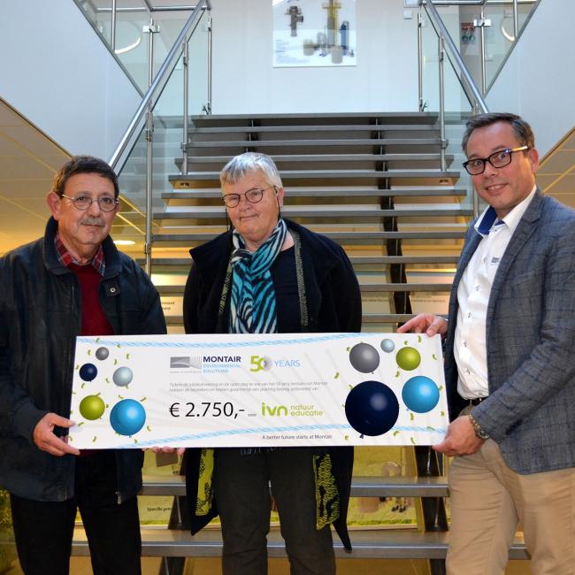 Tom van Asten overhandigt een cheque aan IVN natuureducatie