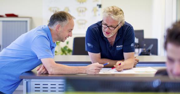 Collega's van Montair bekijken plannen op een tekening